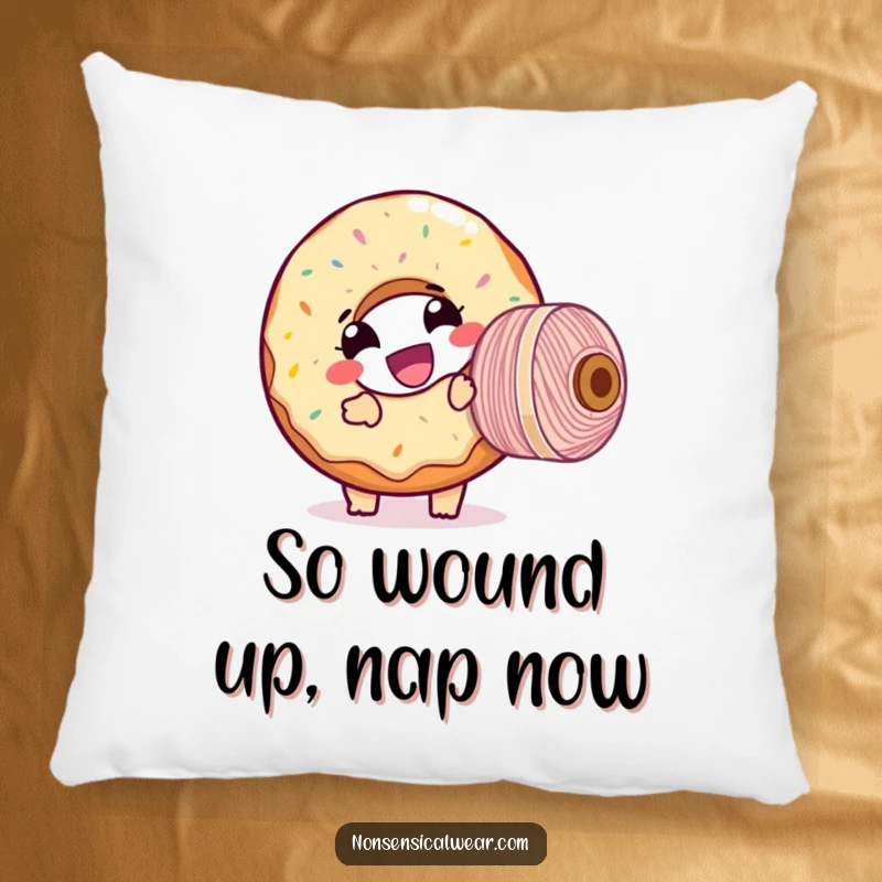 Funny pillow featuring a giggling donut character comically tangled with a large spool of thread, adding humorous comfort.