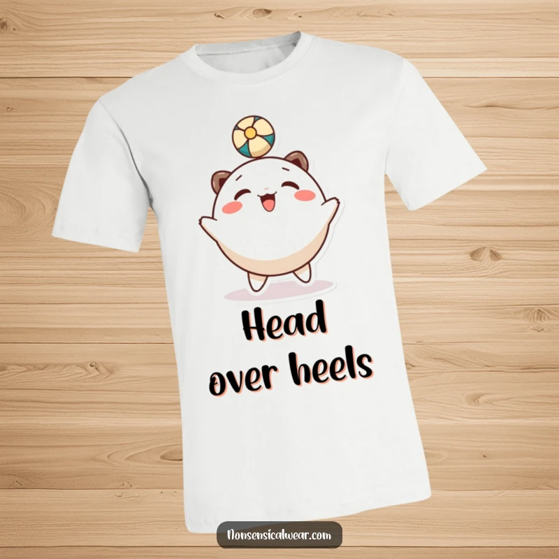 Funny T-Shirt: A smiling, round character is joyfully bouncing a ball with its head in a playful manner.